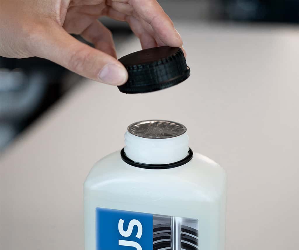 operator opening a bottle of unox commercial oven detergent