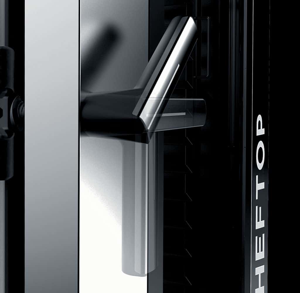 Close-up shot of an oven door with a black handle, which has been moved round, the word cheftop visible on the oven door in white lettering. 