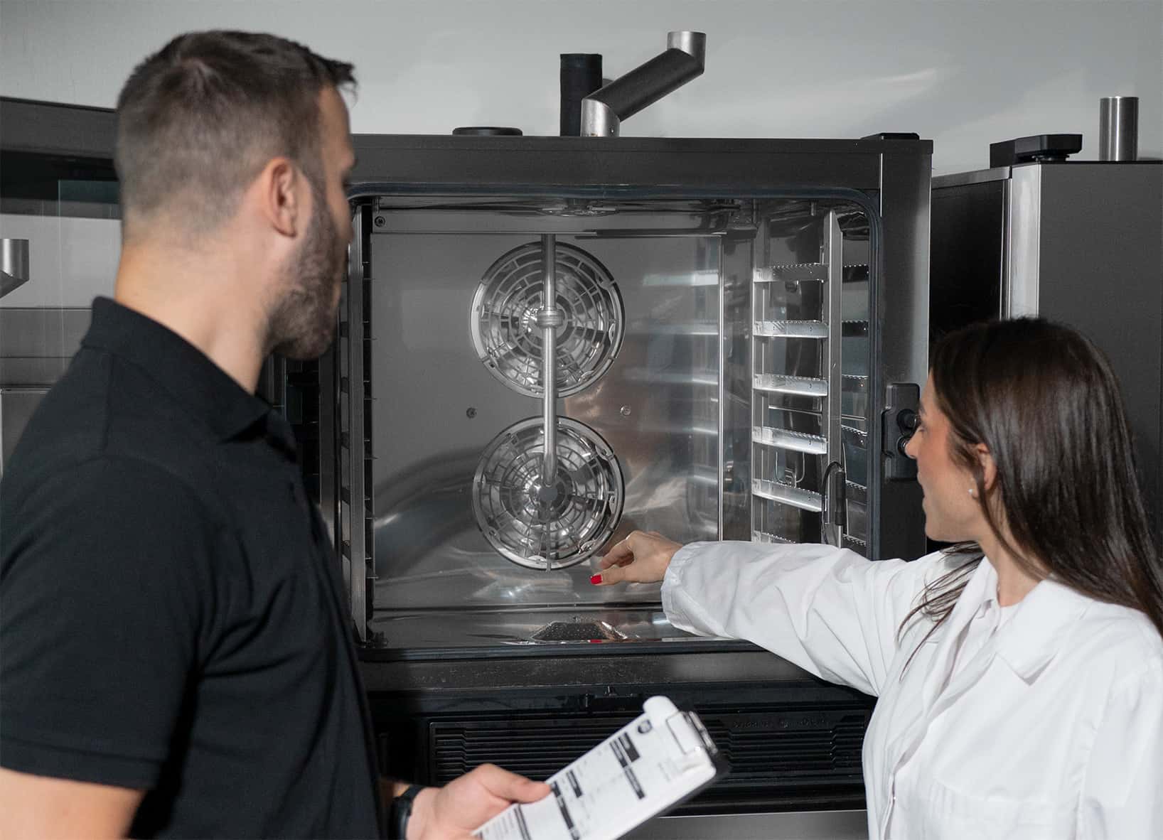 two unox technicians inspecting the spotless cooking chamber of a unox commercial oven