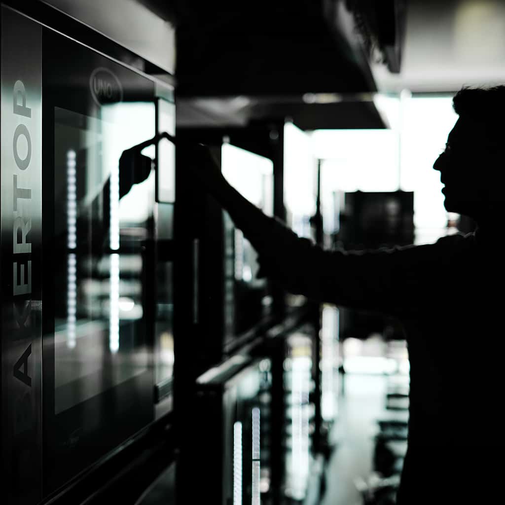 Silhouette of a man touching a panel on an Unox Bakertop combi oven.
