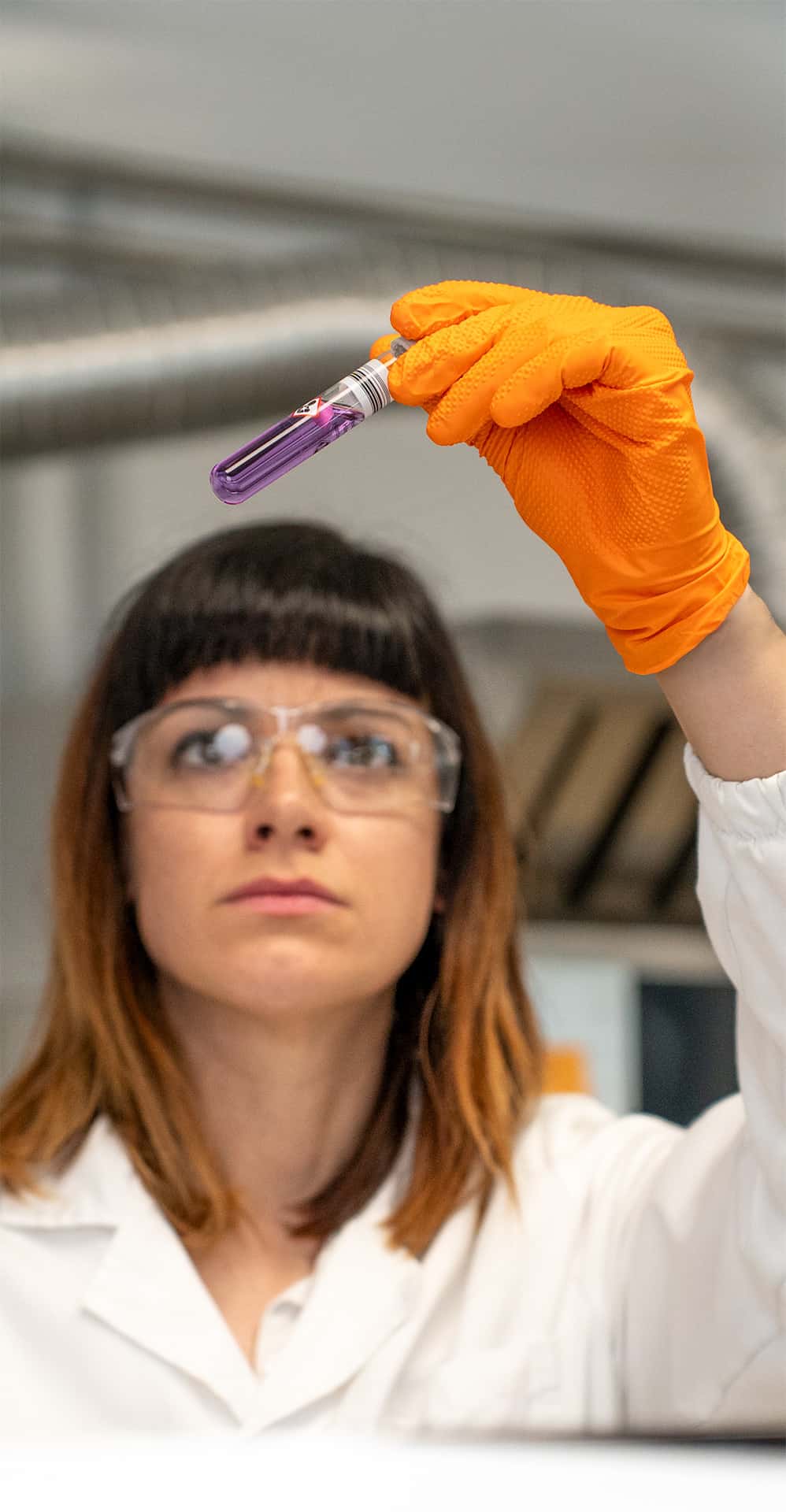 chemist observing a purple test tube in the unox lab