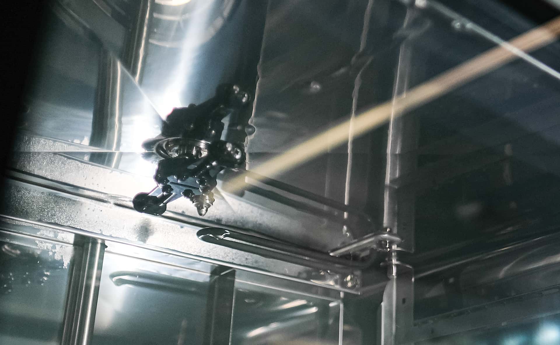 rotating spray arm of a professional oven washing system in action