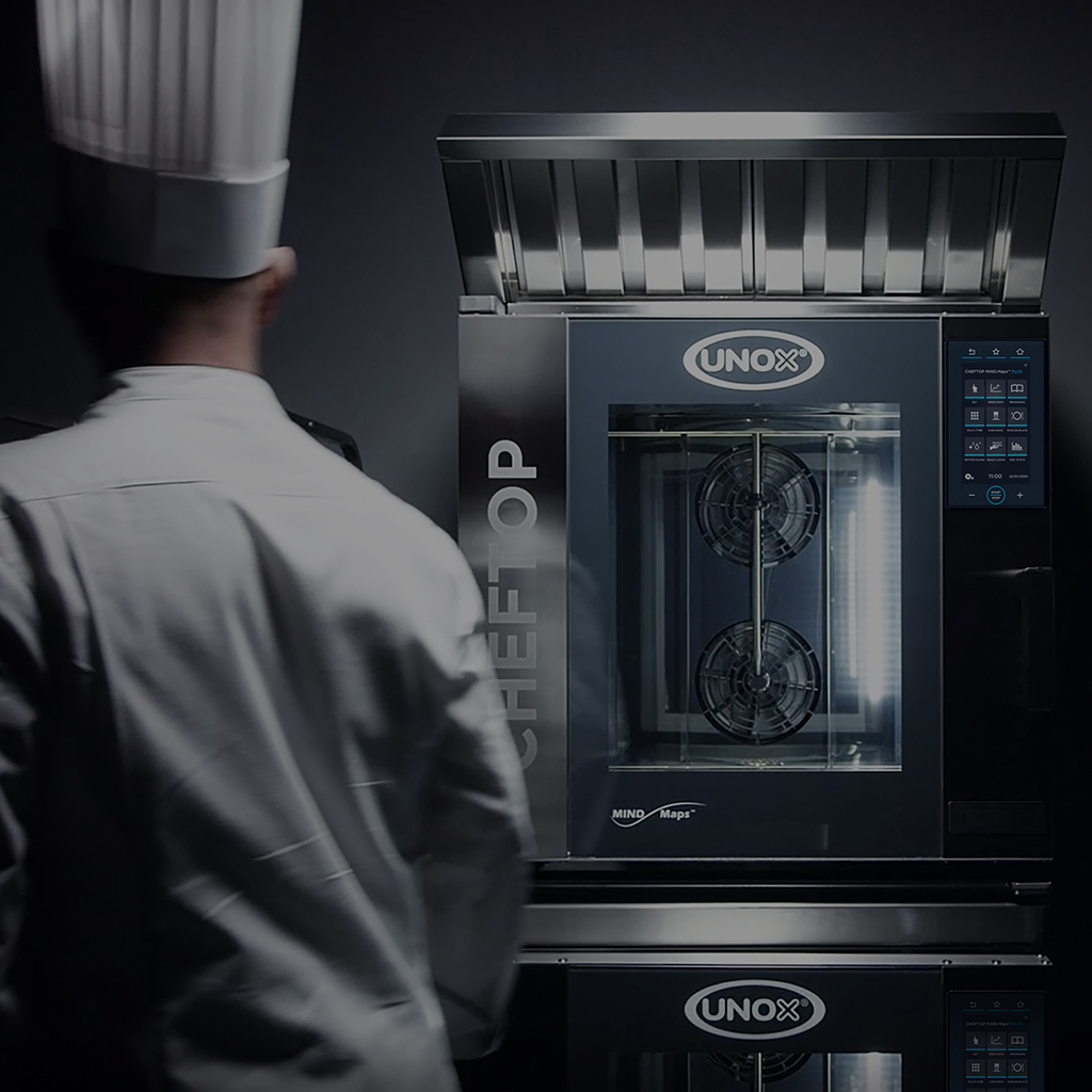 A male chef stood in front of an Unox combi oven.
